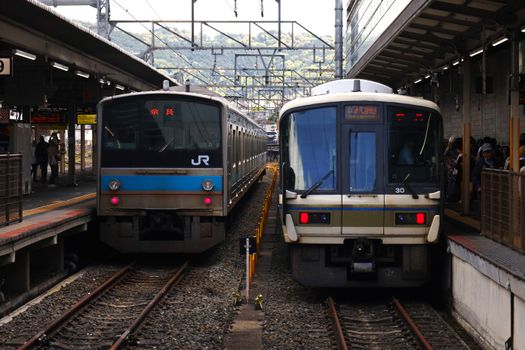 Commuter trains on the Nara Line at Kyoto Station, showcasing Japanese rail efficiency.