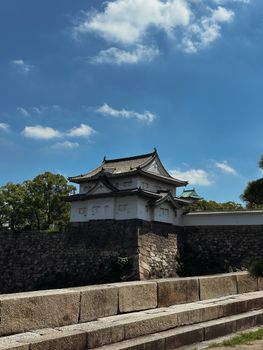 Beautiful view of a traditional Japanese castle on a sunny day with a blue sky backdrop.