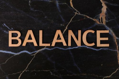 Free Wooden 'Balance' text resting on a dark marble surface, conveying harmony. Stock Photo