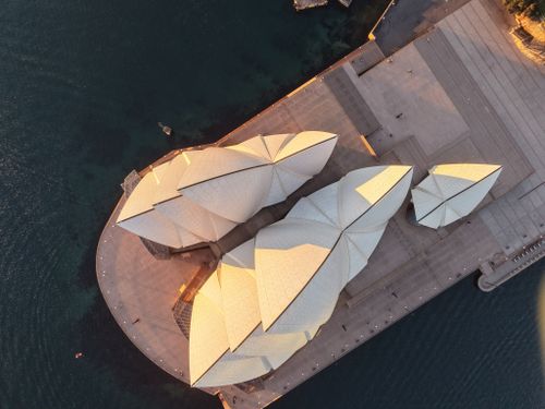 Free Stunning aerial shot of the iconic Sydney Opera House illuminated by sunset. Stock Photo