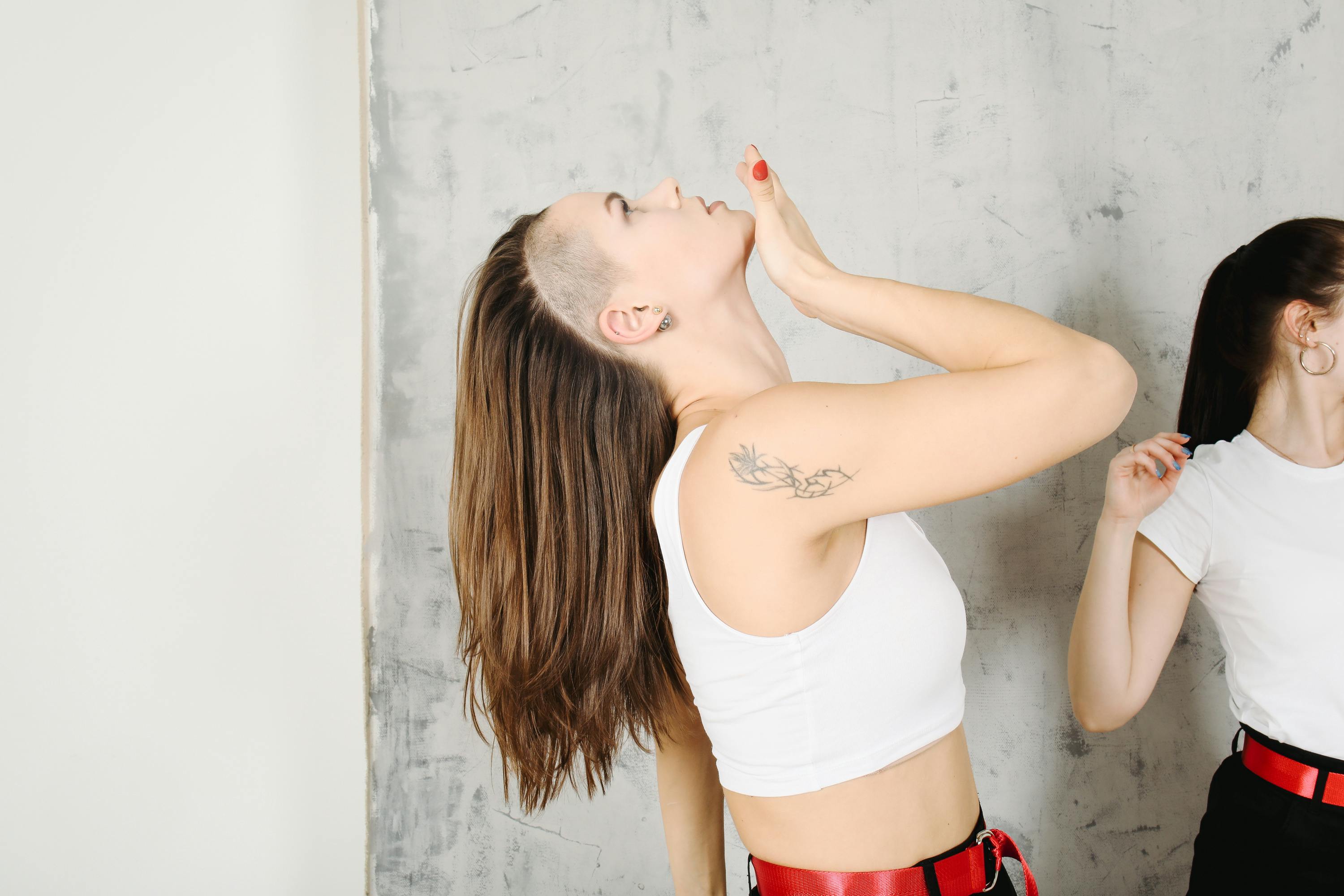 informal with tattoo looking up while dancing in studio