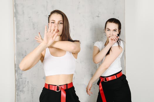 两名年轻女性穿着时尚服装，在工作室里摆出富有创意的姿势