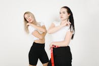 两名年轻女子在白色背景的工作室里摆出时尚舞蹈的姿势