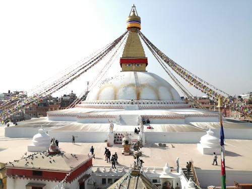 Spherical Boudhanath with white walls and decorative flags strained from spire located in Kathmandu Nepal