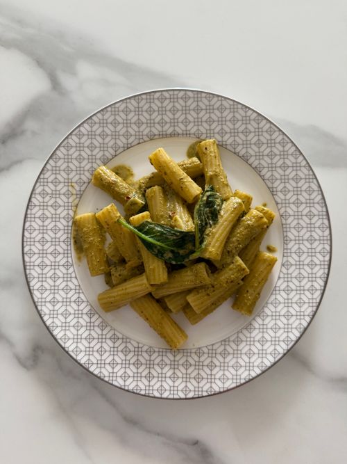 Free Top view of rigatoni pasta with basil pesto sauce on a decorative plate. Stock Photo