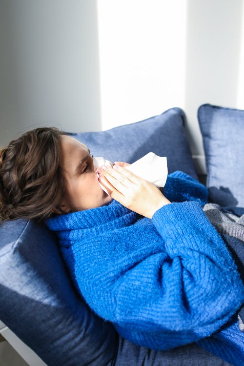 Free Woman in Blue Sweater Lying on Bed Stock Photo