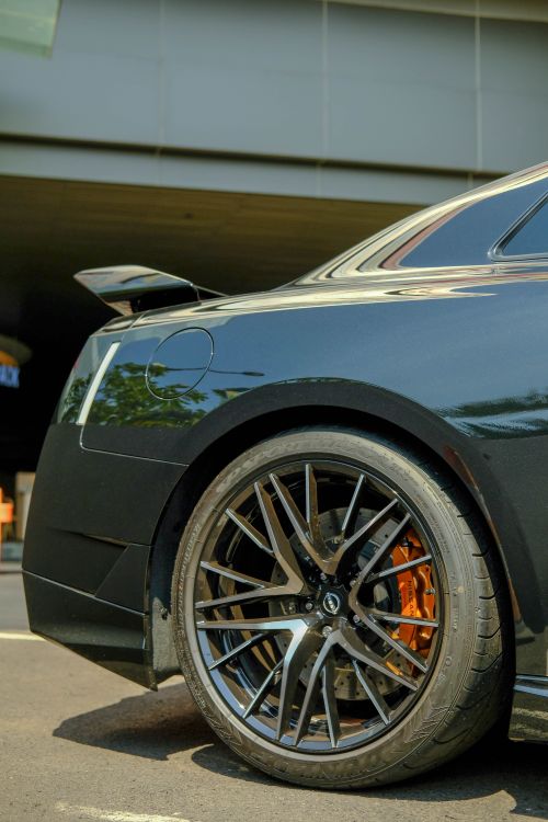 Free Detailed shot of a luxury sports car wheel, showcasing stylish rims and brake features. Stock Photo