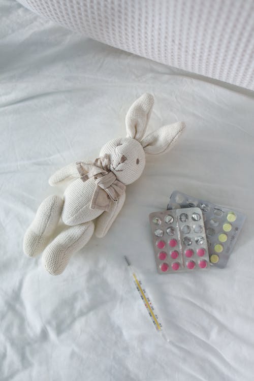 Thermometer and Pills on Bed