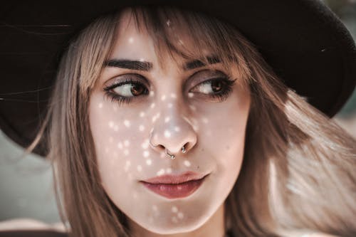 Close-up Photo of Woman Wearing Hat and Nose Ring