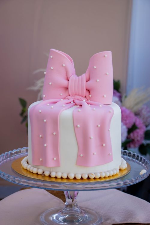 Free A beautifully decorated cake with pink fondant bow and white pearls, perfect for celebrations. Stock Photo