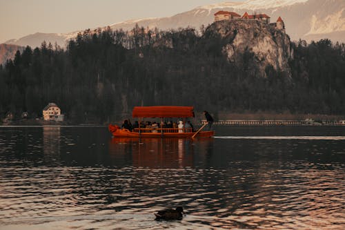 Persone Che Guidano In Barca Sul Lago Vicino Alla Montagna