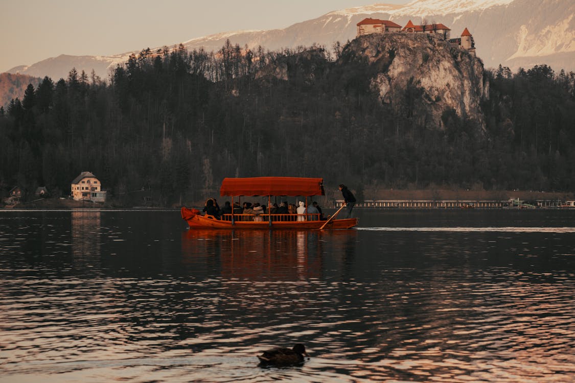 免费 人们骑着小船在山附近的湖上 素材图片
