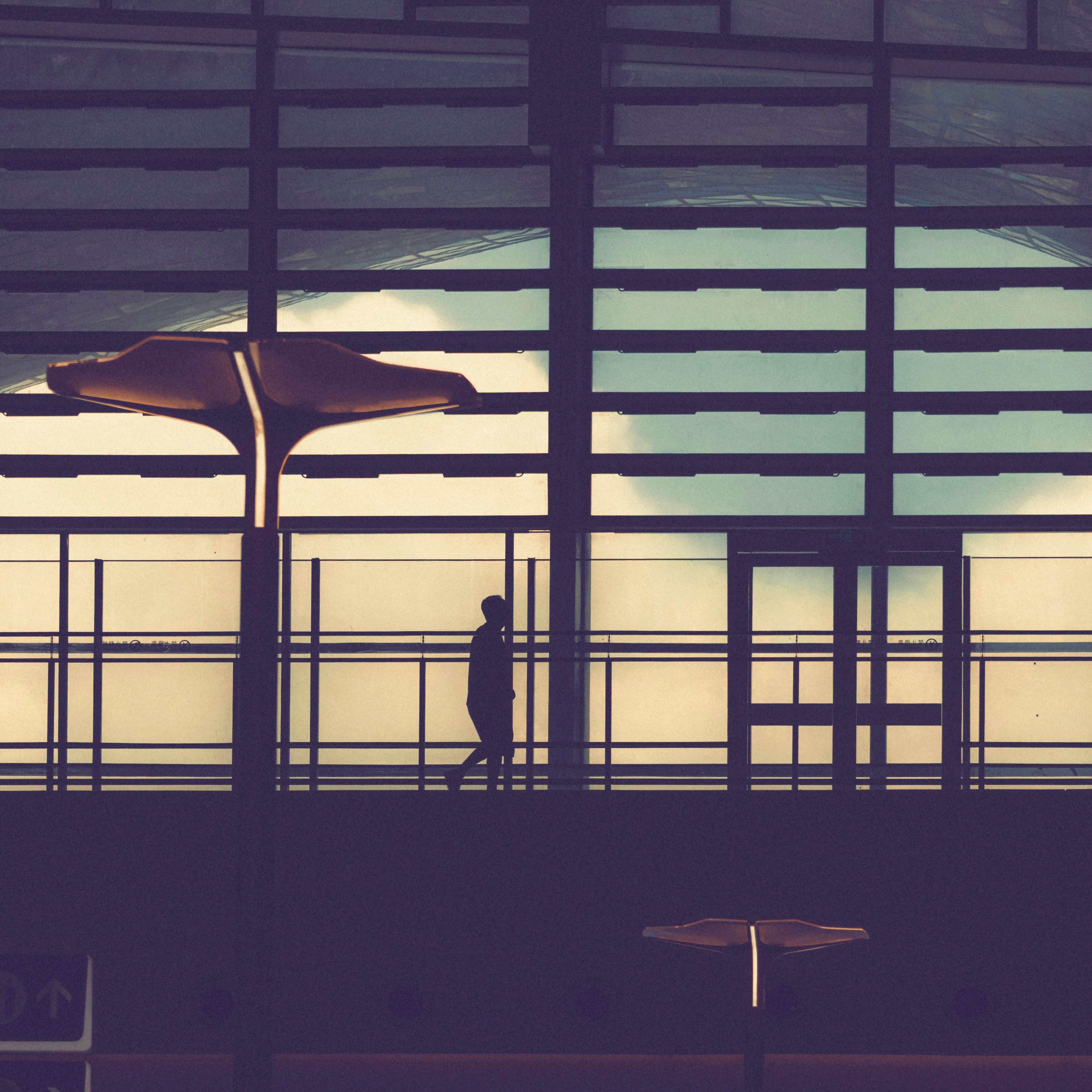 Stylized silhouette of a person in a modern architectural setting with a moody tone.