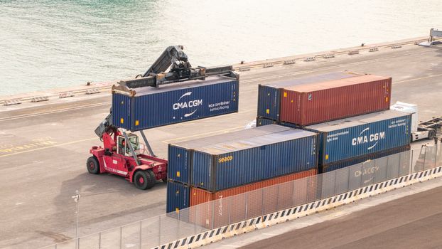 Forklift managing shipping containers at Livorno port, illustrating dockside logistics and cargo handling.