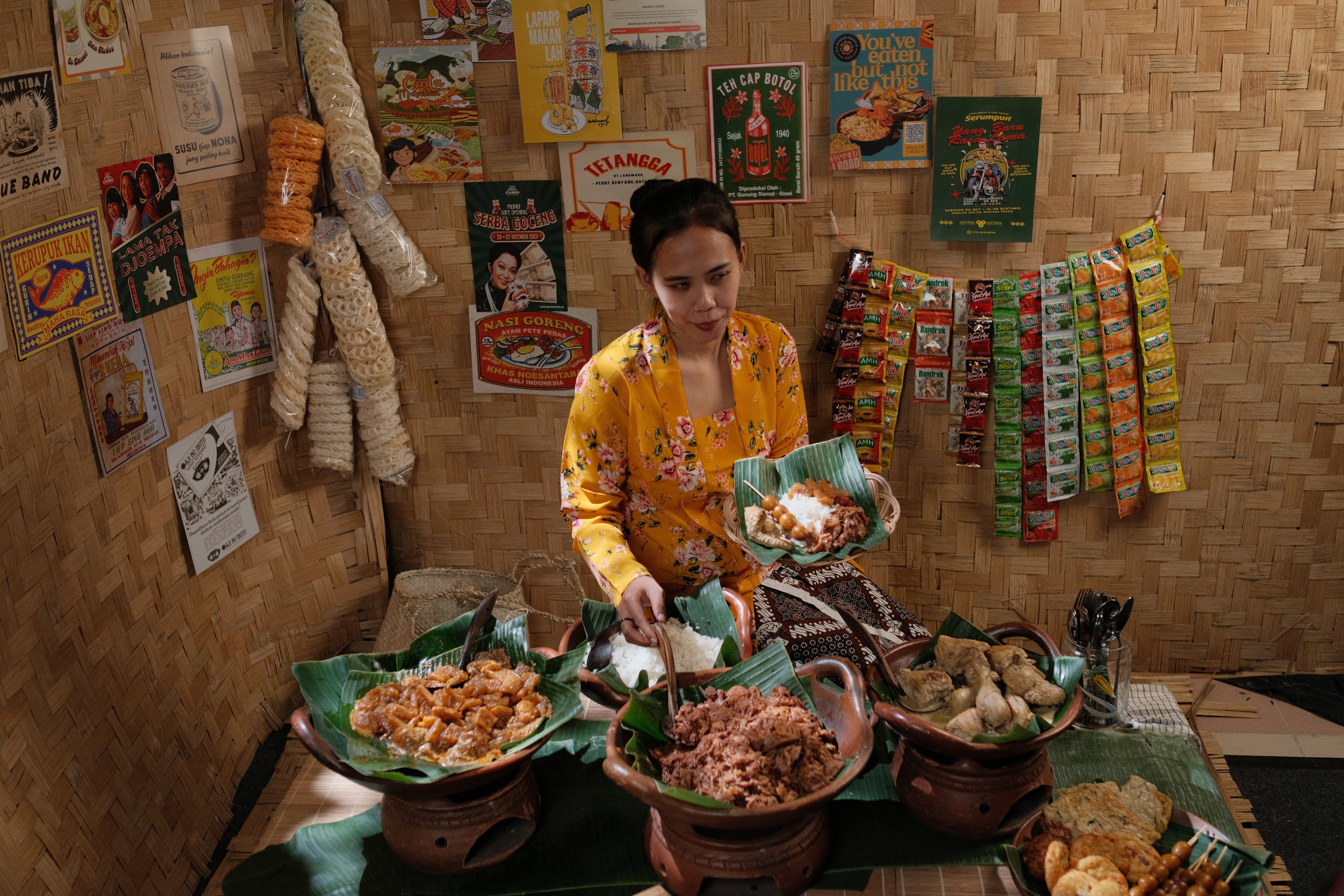 Woman serving traditional Indonesian food at a bamboo stall in Jakarta.