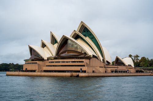 Free Dramatic view of the Sydney Opera House from the harbor, showcasing its iconic architecture. Stock Photo