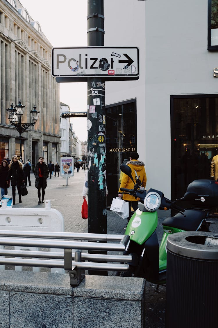 Street Of Modern City With Sign And Green Scooter