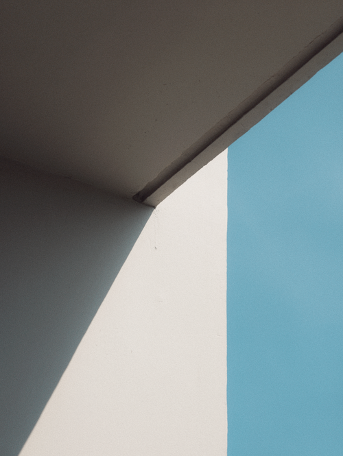 Free A minimalist shot of architecture in Vietnam with shadows casting against a clear blue sky. Stock Photo