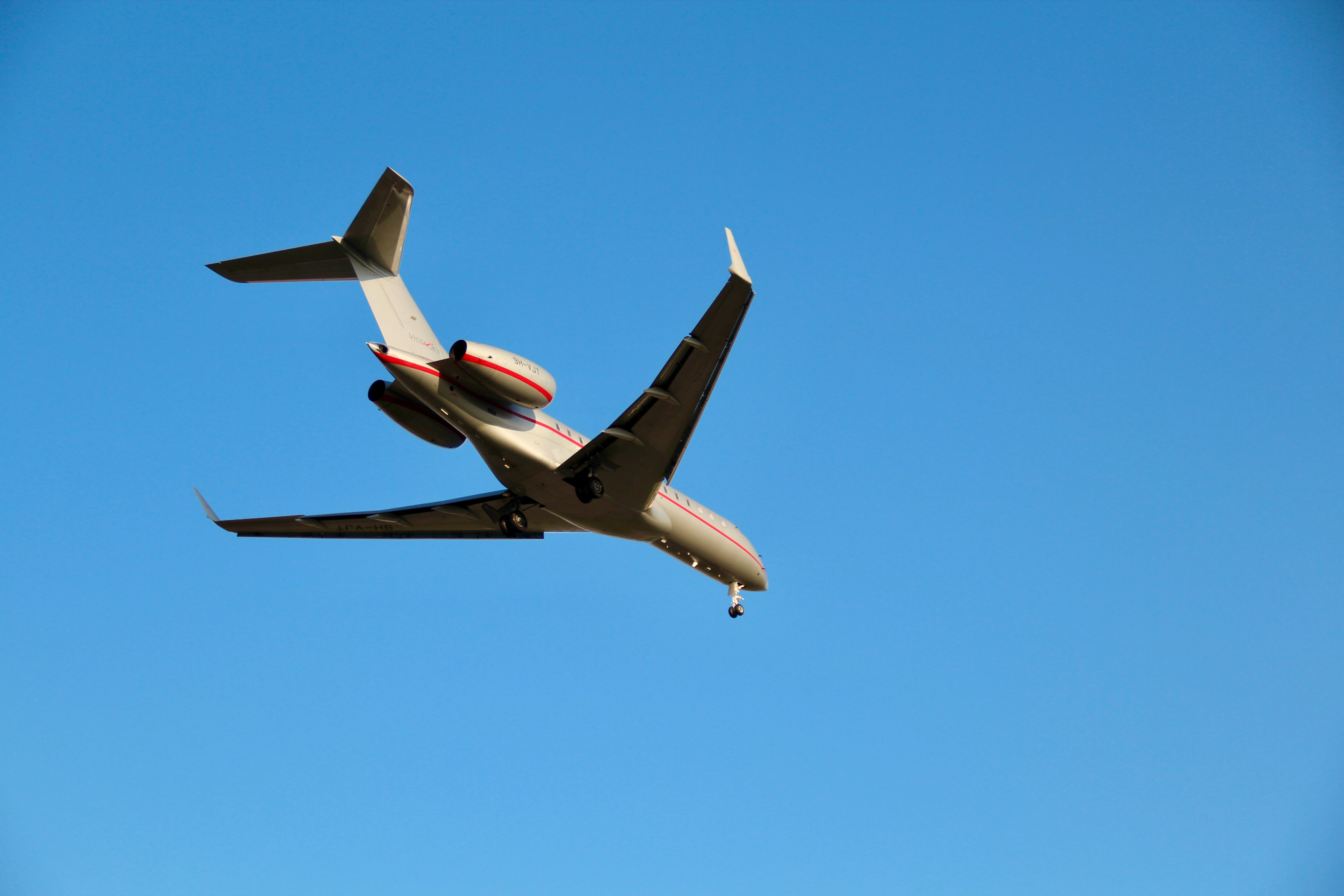 A private jet soars gracefully against a vibrant blue sky, showcasing modern aviation.