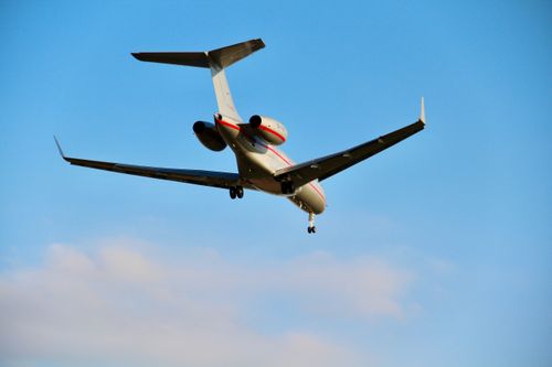 Free Luxurious private jet flying through the clear blue sky on a sunny day. Stock Photo