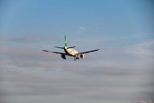 Free A commercial airplane captured from behind as it descends for landing against a clear blue sky. Stock Photo