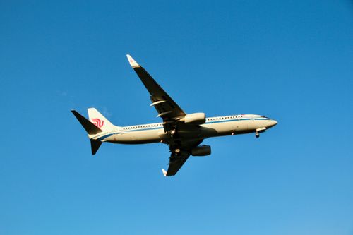 Free A commercial airplane captured mid-flight under a clear blue sky, showcasing aviation technology. Stock Photo