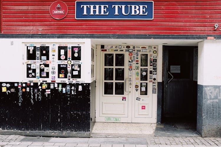 Exterior Of Modern Pub With Doorway Under Sign On Wall