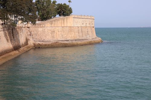 Free A scenic view of a historic fortification by the sea in Cádiz, Andalucía, Spain, capturing the serene coastal atmosphere. Stock Photo