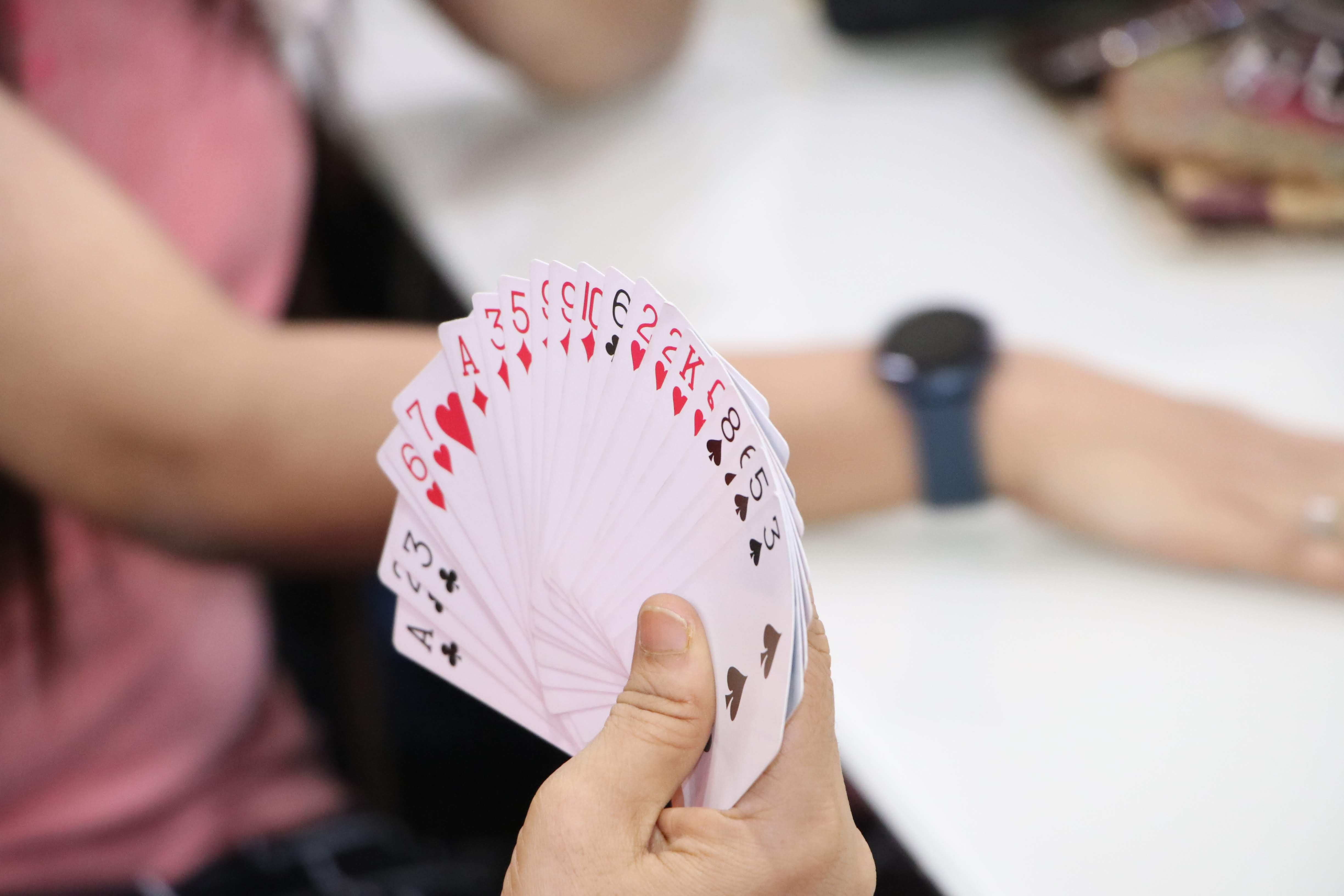 Close-up of a person holding a fan of playing cards, perfect for game or poker-related visuals.