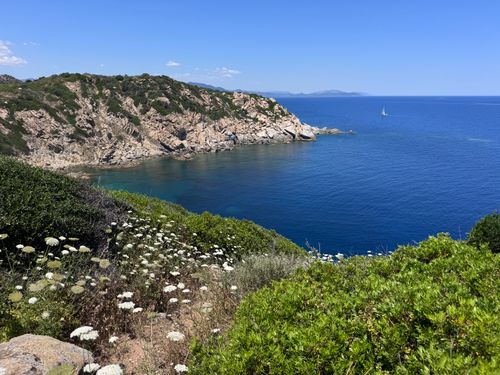 Free Breathtaking view of Sardinia's coast with a sailboat on the horizon under blue skies. Stock Photo