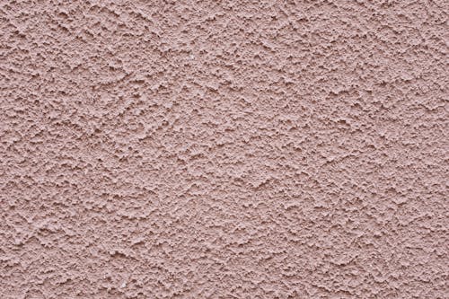 Free Simple background of uneven stucco pink wall surface of modern building in city Stock Photo