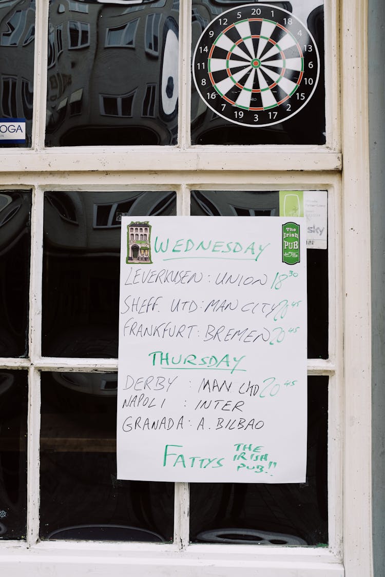 Blackboard With Timetable Hanging On Entrance Of Cafe