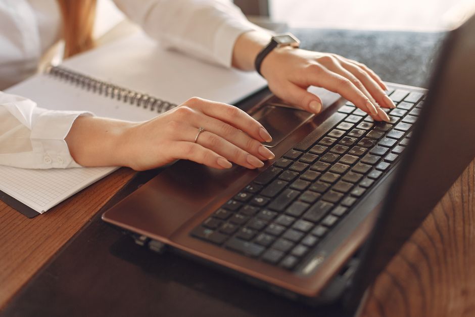 person typing laptop content writing desk