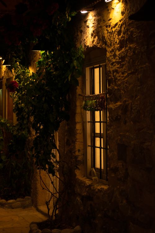 Free Warm ambient lighting on the exterior of a rustic stone house at night. Stock Photo