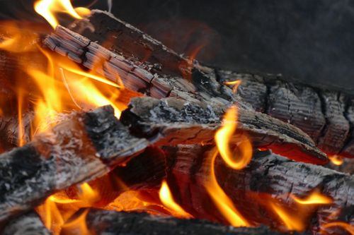 Free Detailed close-up of burning firewood with vivid orange and yellow flames. Stock Photo