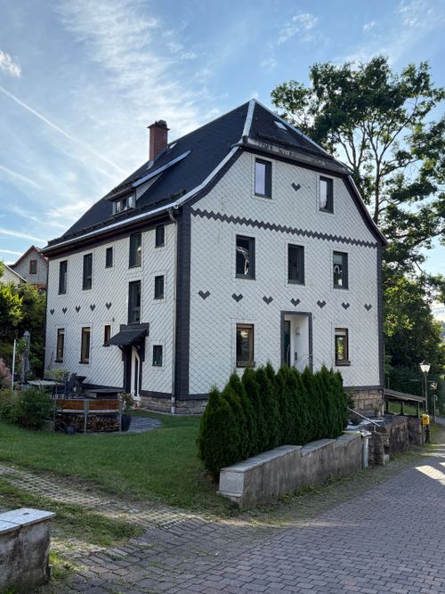 Free Elegant two-story white house with rustic design in a quaint village setting. Stock Photo