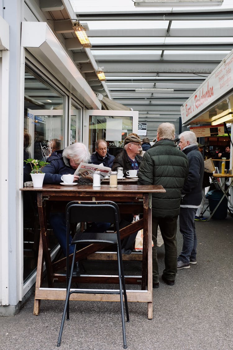 Group Of Men Outside A Coffee Shop