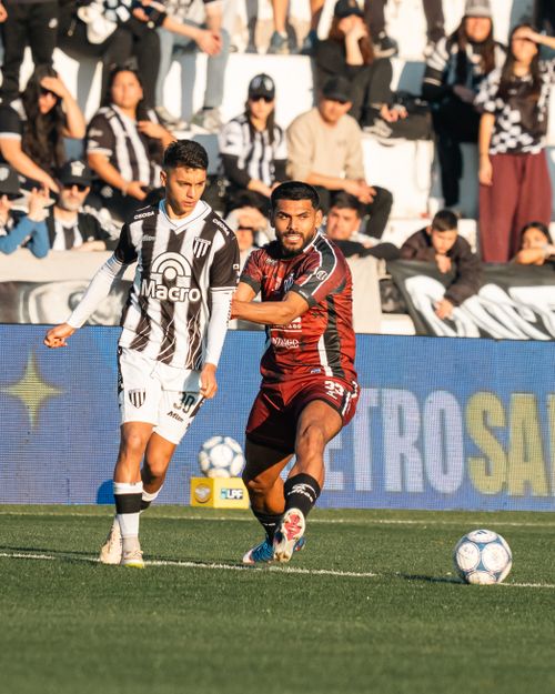 Free Two soccer players in action during a competitive match with spectators in the background. Stock Photo