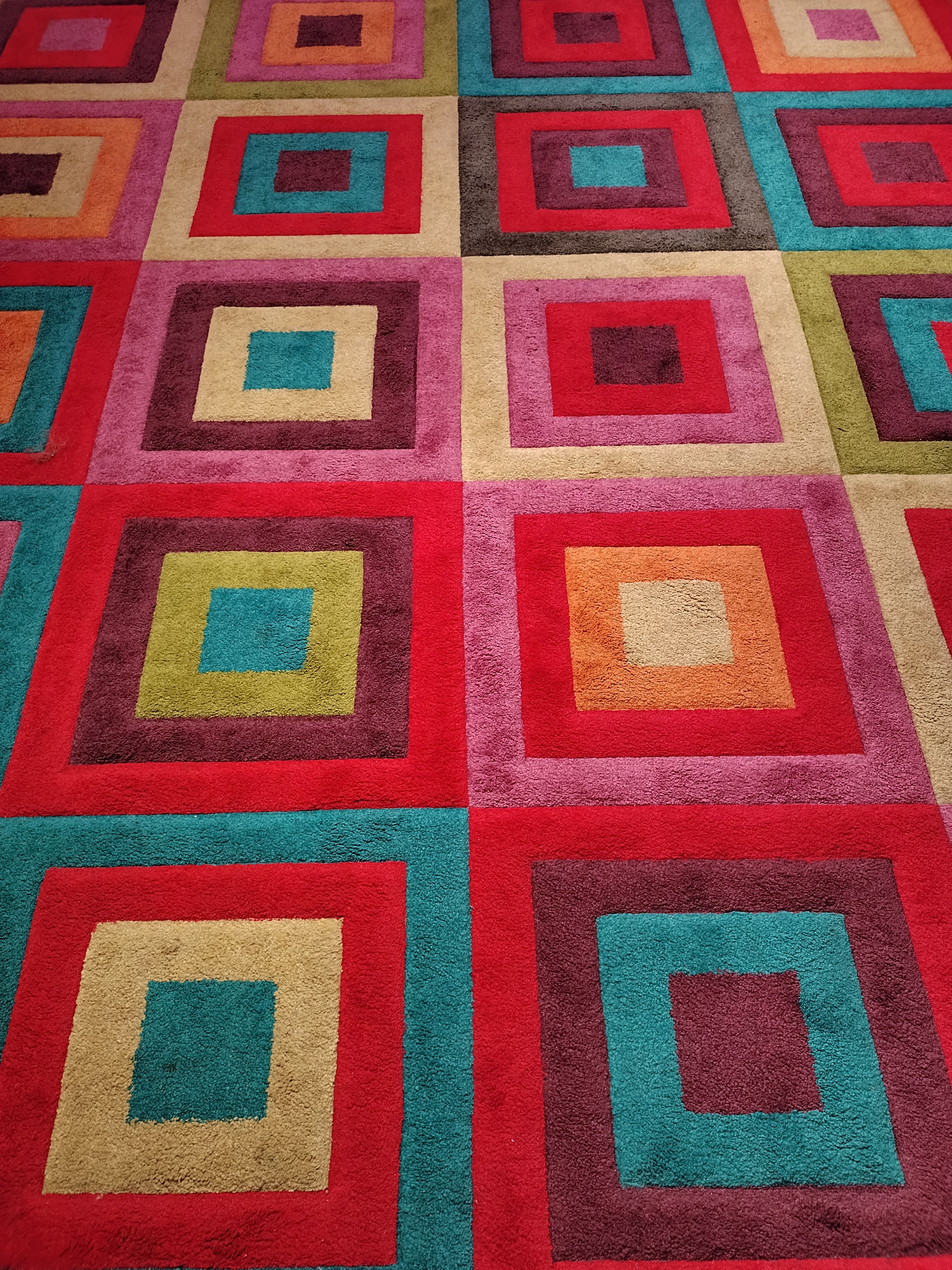 Brightly colored geometric patterned carpet with squares, ideal for modern interiors.