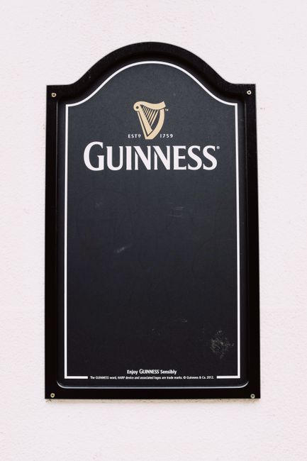 Stylish black chalkboard with decorative top designed for writing menu hunged on gray wall in city street