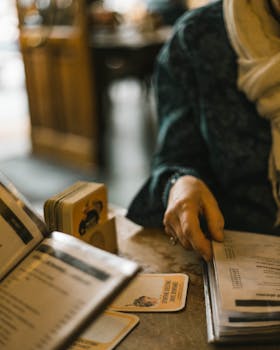 An adult browsing a restaurant menu in a cozy Brussels setting. Warm, inviting atmosphere.