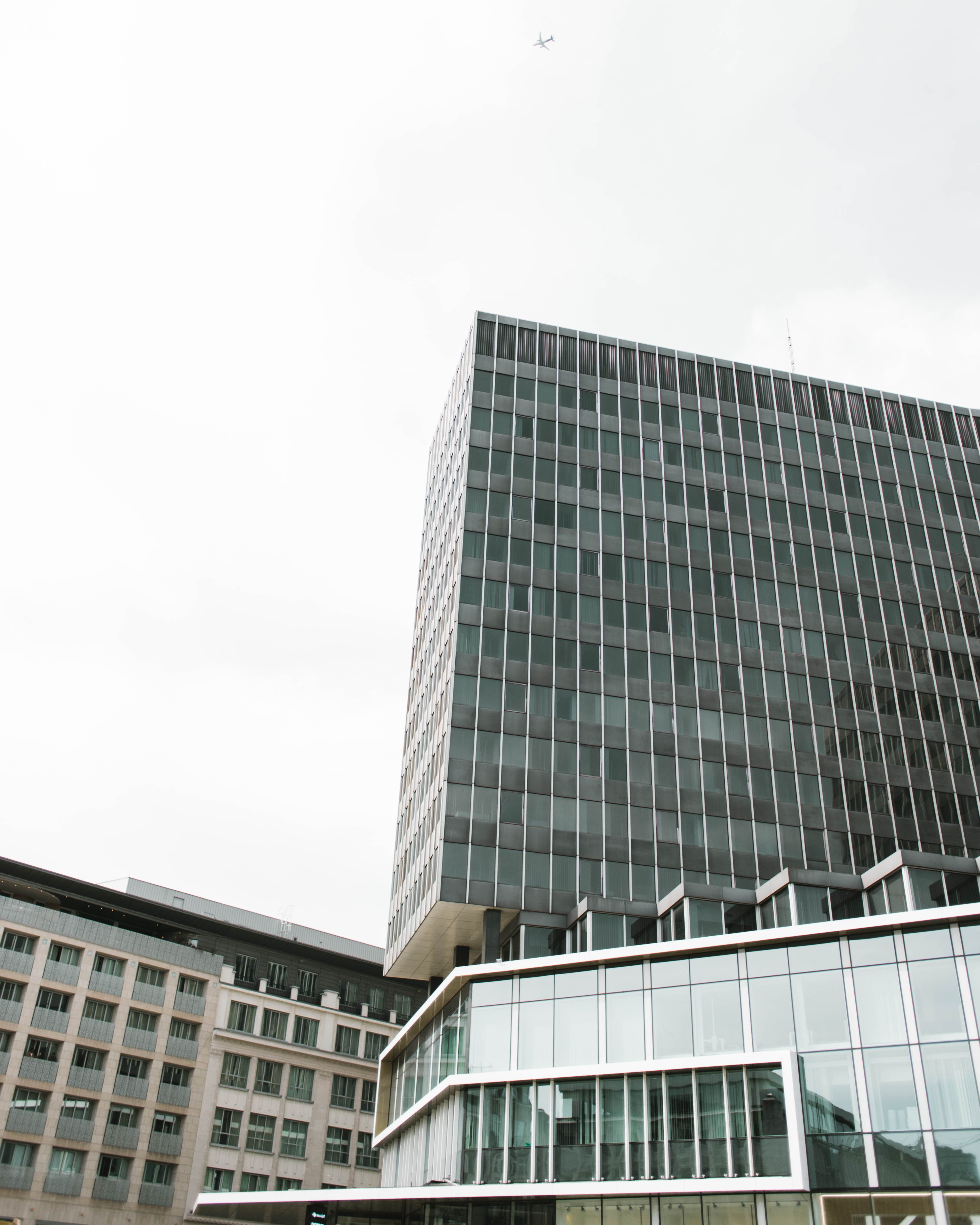 High-rise office buildings in Brussels with a plane flying overhead, creating a dynamic urban scene.