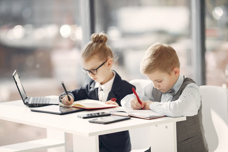 Focused Kids Colleagues Writing Notes In Daily Planners In Modern Office