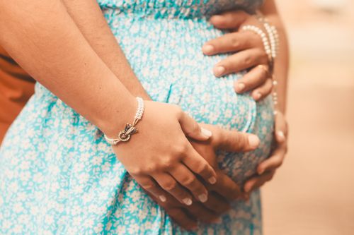 Free Close-up of a couple's hands tenderly embracing a pregnant belly, symbolizing love and anticipation. Stock Photo