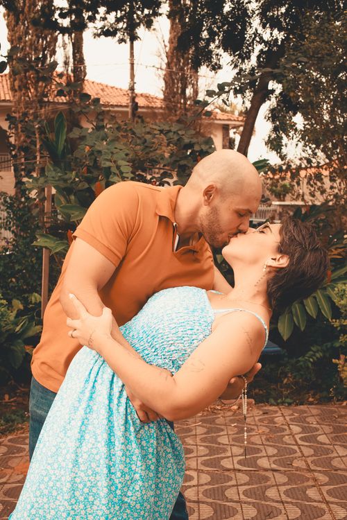 Free A couple embraces and shares a kiss in a beautiful garden setting, showcasing romance and affection. Stock Photo