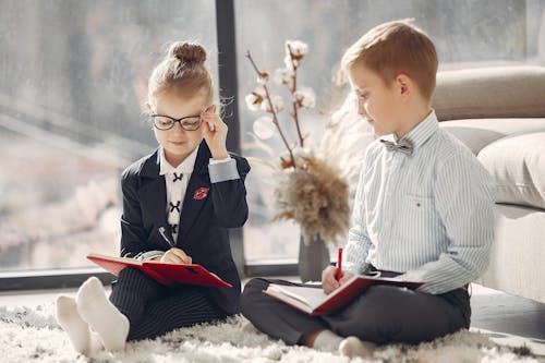 Smiling business kids with daily planners at home