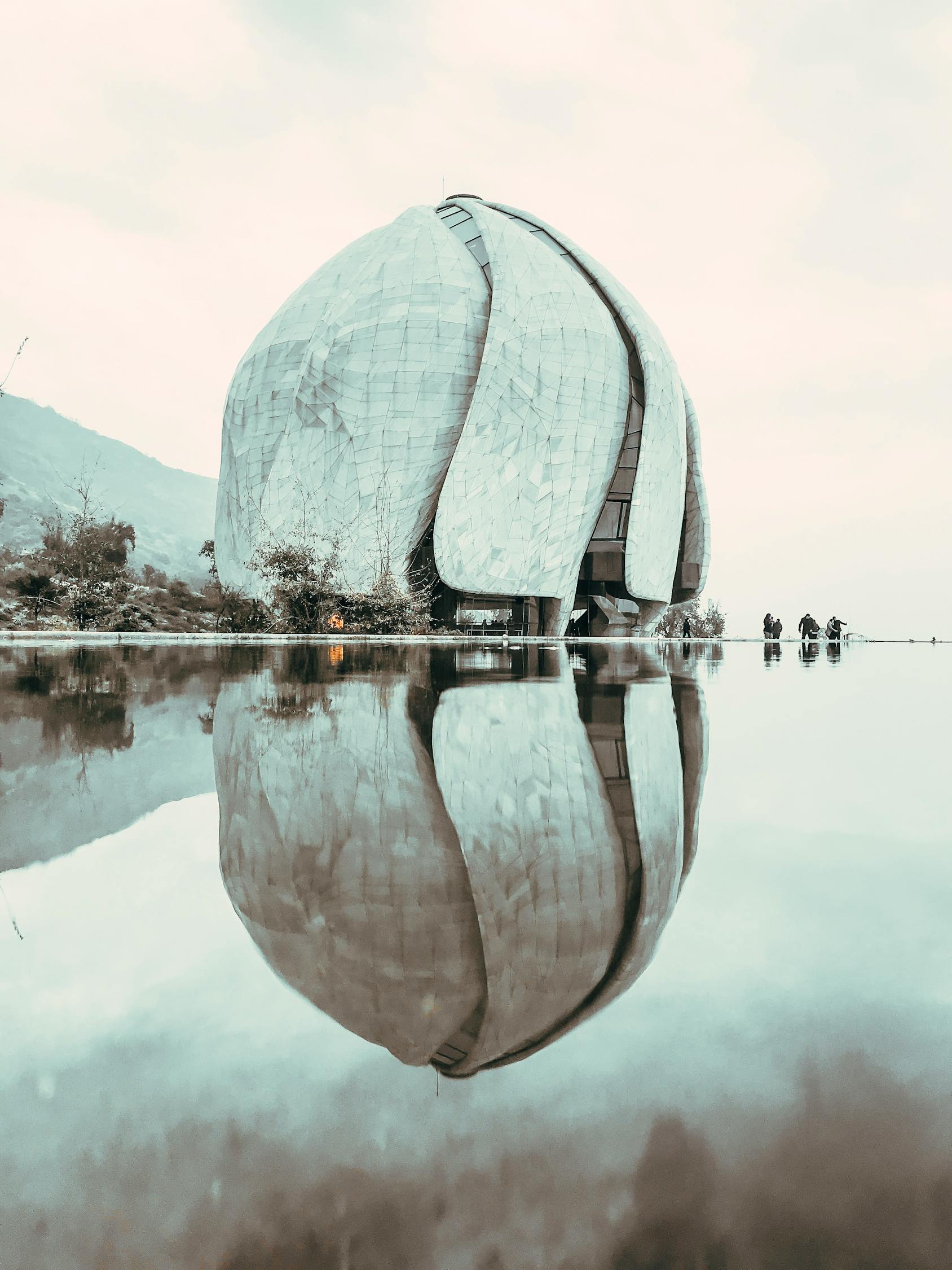Facade of contemporary spherical House of Worship composed of marble wings located in Santiago on waterfront