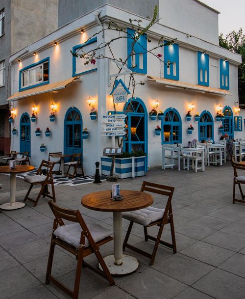 Free An inviting outdoor cafe with blue and white decor, perfect for a relaxed city evening. Stock Photo