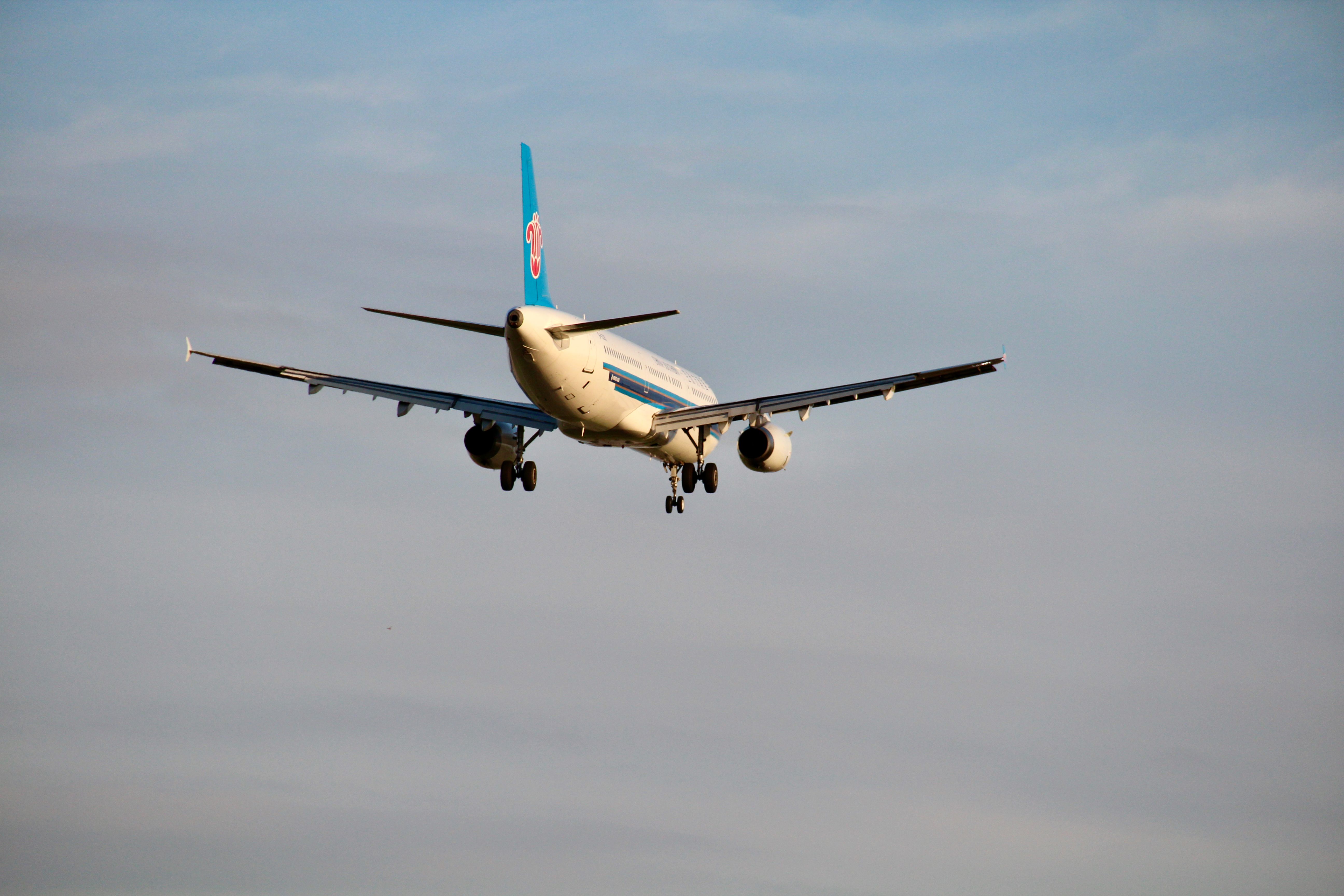 A commercial airplane captured mid-flight against a clear blue sky, showcasing aviation travel.