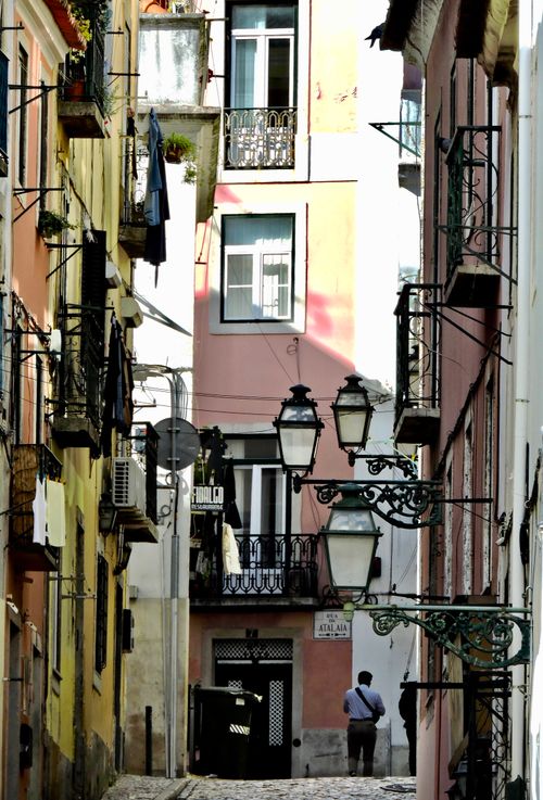 Free Discover a vibrant Lisbon street with classic architecture and vibrant colors, inviting exploration. Stock Photo
